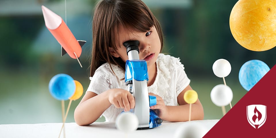 child looking in microscope