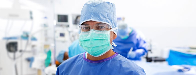 male surgical technologist in scrubs and mask