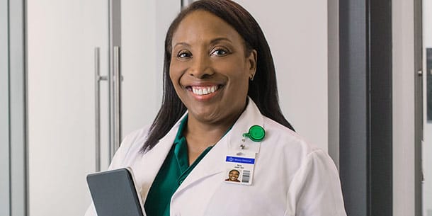 smiling female nurse doctor wearing lab coat in medical office