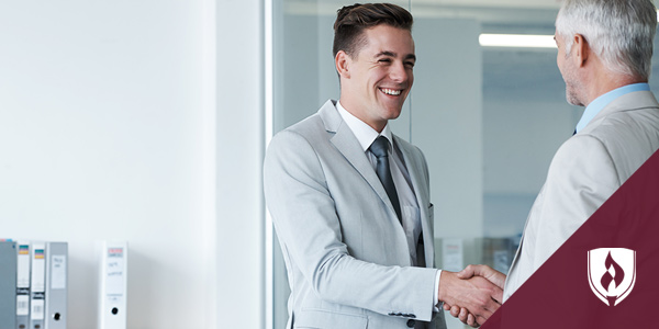 young business man shaking hands with older business man