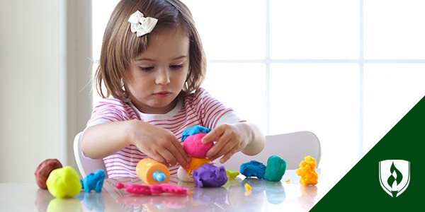 photo of a toddler playing with playdough representing sensory activities for toddlers