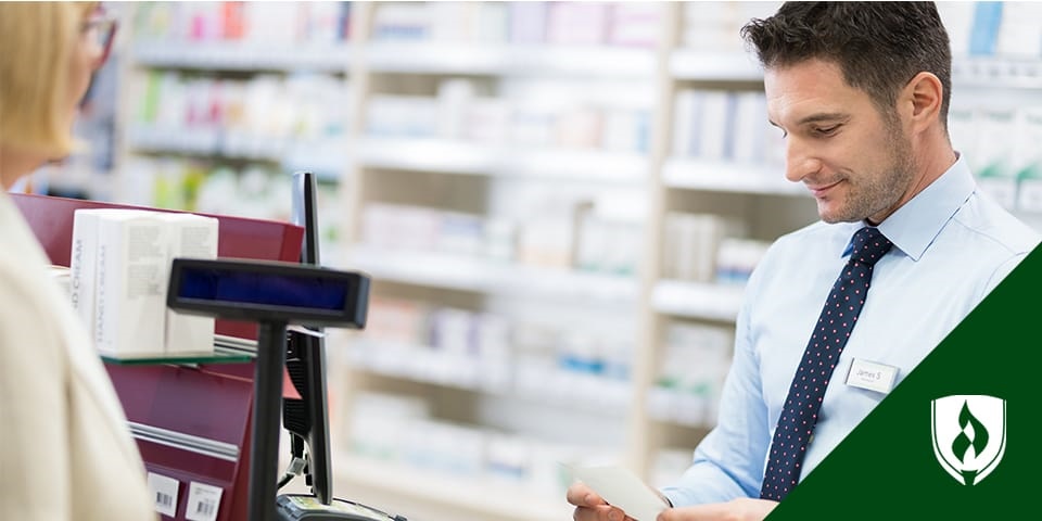 male pharmacy technician helping customer at checkout