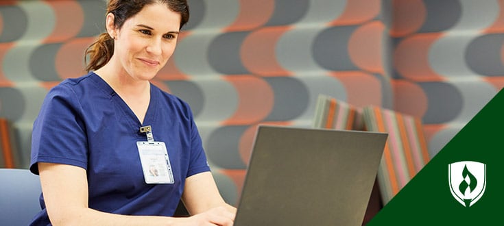 Smiling nurse looking at laptop