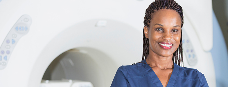 female technician in front of MRI scanner