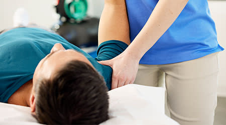 therapist adjusting patient arm and shoulder