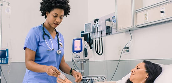 nurse checking the oxygen saturation of patient in hospital bed