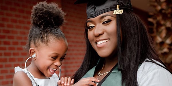 Female graduate holding young child