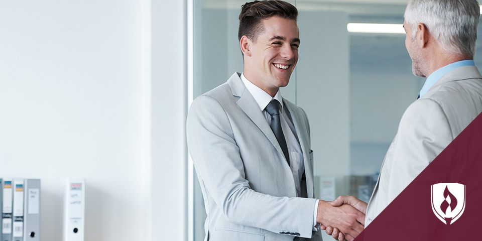 young business man shaking hands with older business man