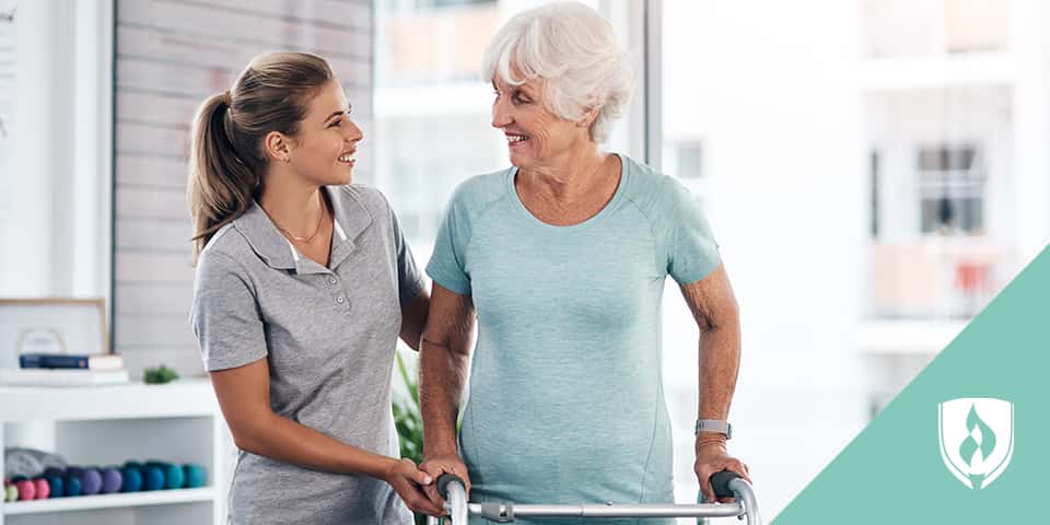 physical therapist assistant helping elderly patient
