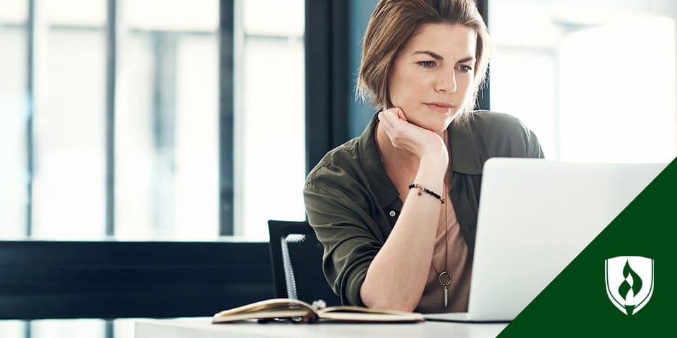 Photo of a woman looking intently at a laptop.