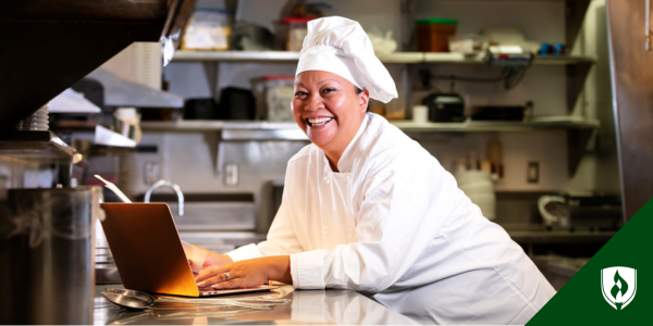A chef works on the computer in her small business kitchen