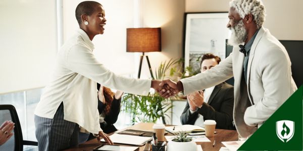 Two business people shake hands over a prototype