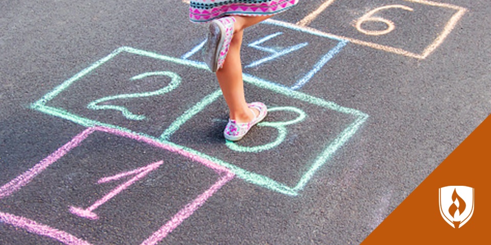 Photograph of a preschooler playing hopscotch to help them learn math skills