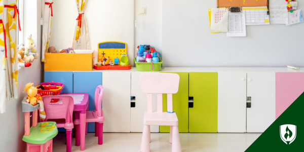 A colorful daycare or preschool shown empty with cute cupboards and a few pink toys