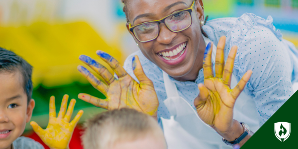 ECE certificate holder paints with children at a daycare