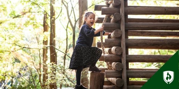 A child climbs up a log structure