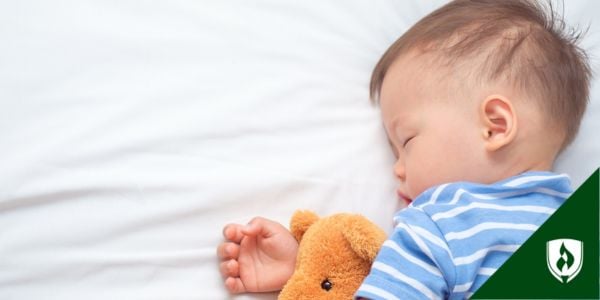 A baby asleep with a teddy bear