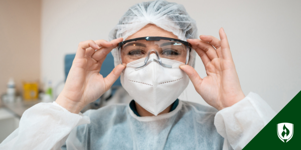 A smiling surgical tech adjusts her protective eye equipment