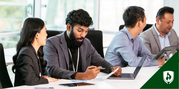 A legal secretary smiles and points to an agenda item during the meeting