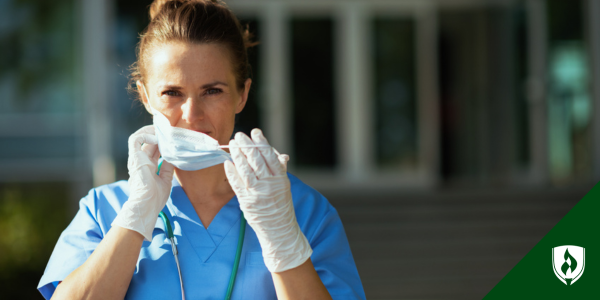 A nurse in Florida puts a face mask on while wearing gloves