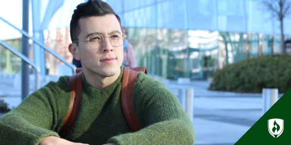 A prospective nursing student in a green sweater contemplates how he will pay for nursing school