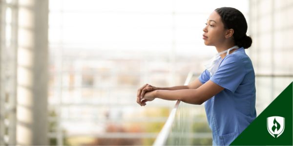 A nurse looks out over the hospital courtyard