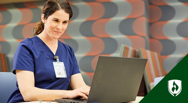 Photo of a student nurse working at a laptop.