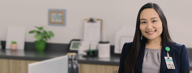 smiling female healthcare professional standing next to desk