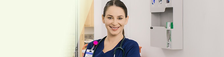 Smiling nurse in blue scrubs with badge and stethoscope