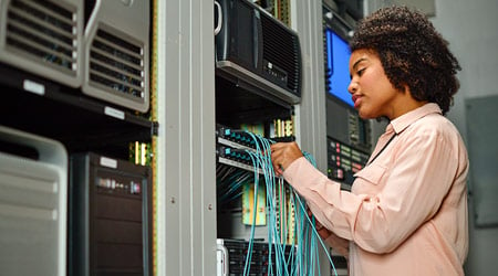 female network systems administrator working on a server