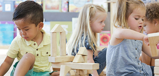 multiple children playing with building blocks