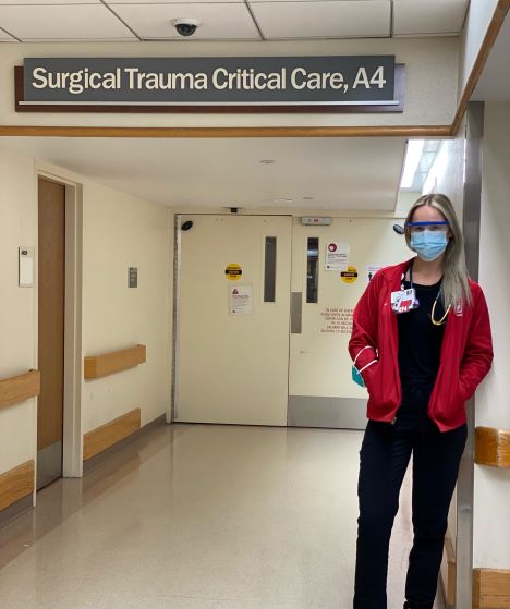 trauma nurse standing in hospital hallway with stethoscope and mask